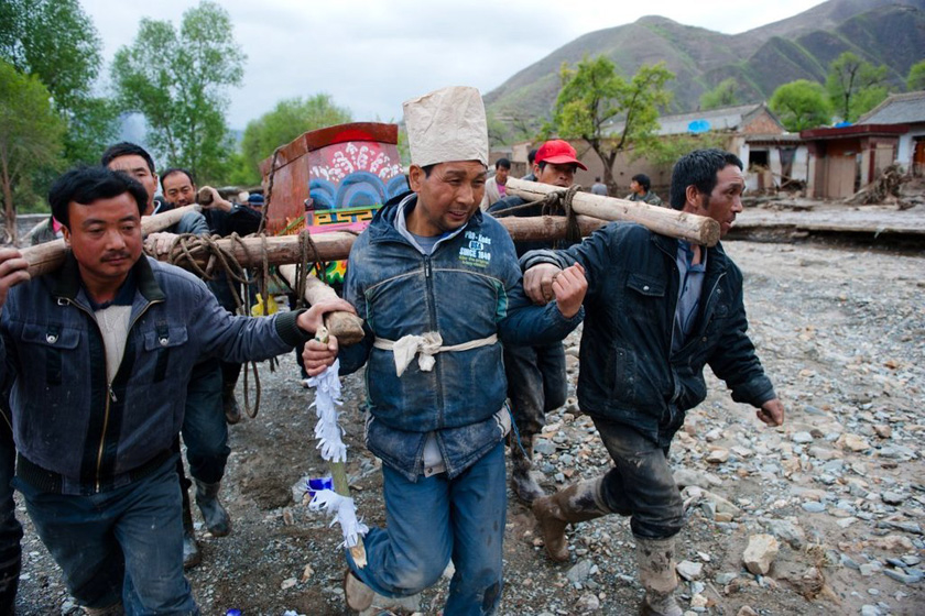 5月13日,甘肃岷县,亲戚乡邻抬着后寿娃的老人的棺材前行.