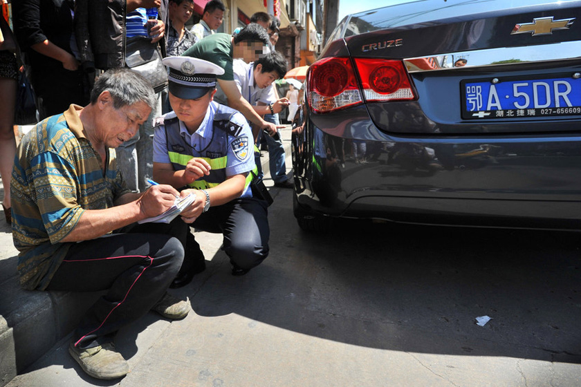 9月14日,武汉,交警赶来认定小车司机负全责,板车师傅脱围.