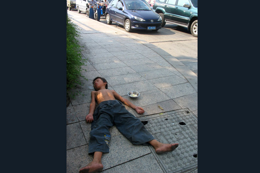 2011年8月2日上午,江西上饶市区信江大桥上,一位衣着破烂的男孩熟睡在