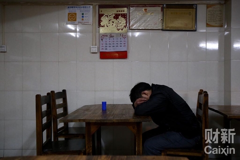 我爸在打瞌睡。团年饭他和二叔喝了很多酒，但夜间工作一直积极。一屋暗灯，我看着睡倒一片的他们，像一团团疲惫蜷缩的动物，头一次那么真切地觉得他们老了。 夏伟聪/财新记者