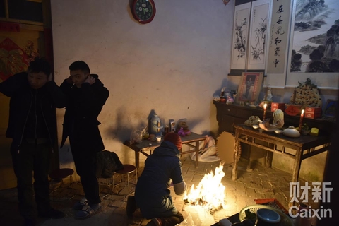 妻弟丁森一家早上起床后，他的母亲在堂屋化纸钱祭神，父亲在院子里放鞭炮，开始充实的大年初一。丁森和哥哥丁浩被父亲从梦中叫醒，还在迷瞪。每年的这一天，父母四点多就起床，操办好一切，然后喊孩子们起床，带着他们祭神、给长辈拜年。 陈亮/财新记者