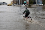 伊拉克受强降雨袭击 行人涉洪前行