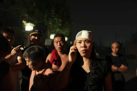 9月7日凌晨，北京西山华府南门，受伤的女士给朋友打电话，她丈夫受伤严重在医院接受治疗。新京报浦峰/CFP