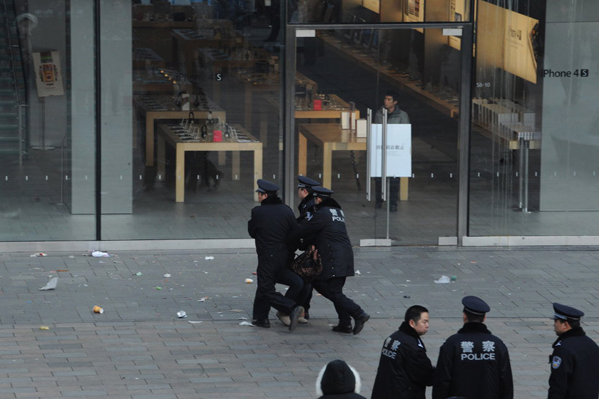 1月13日早上9点，位于北京三里屯的苹果旗舰店打出“排队到此截止”的告示，警察驱散人群。  江心/CFP_苹果三里屯店停售iPhone4S 遭黄牛扔鸡蛋