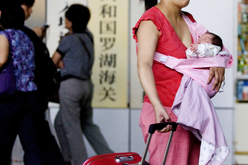 2007年5月18日,在罗湖关口，一名刚到香港生完孩子的妈妈自己拉着行李出关。  CFP_育儿“战”