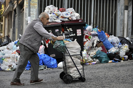 2011年6月，在希腊大批债务即将到期的关键时刻，穆迪等把希腊主权信用评级降至全球最低水平，即“垃圾级”。这是10月14日，一名老人推车经过希腊雅典街头的垃圾堆。
