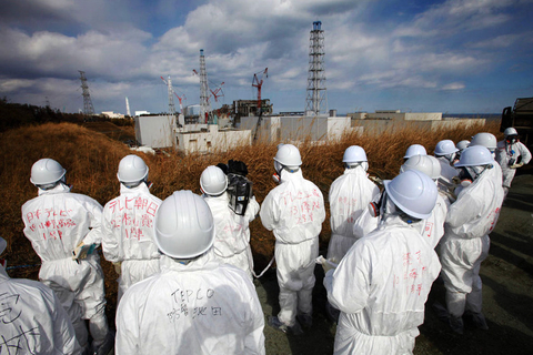2月20日，日本福岛县福岛第一核电站，记者身穿防护服在东电工作人员的陪同下采访。 东方IC