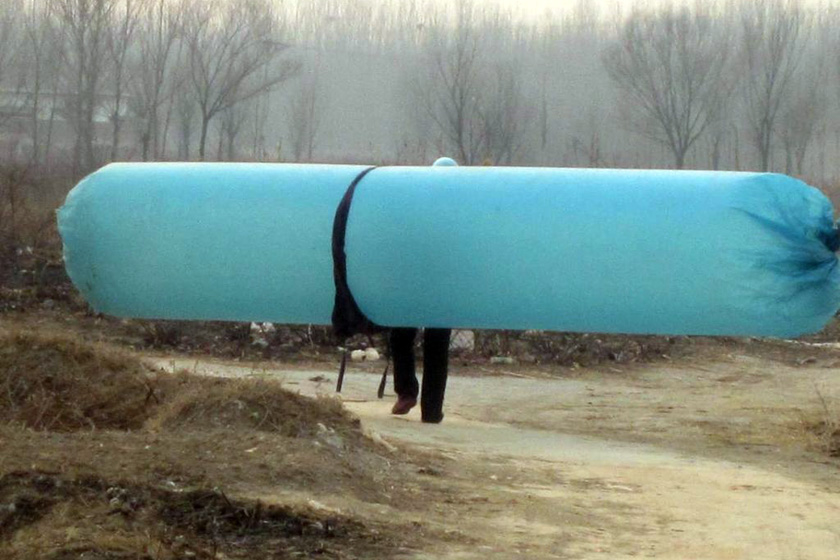 2月20日,山东滨州市,一村民背着长约6米的天然气包回家.