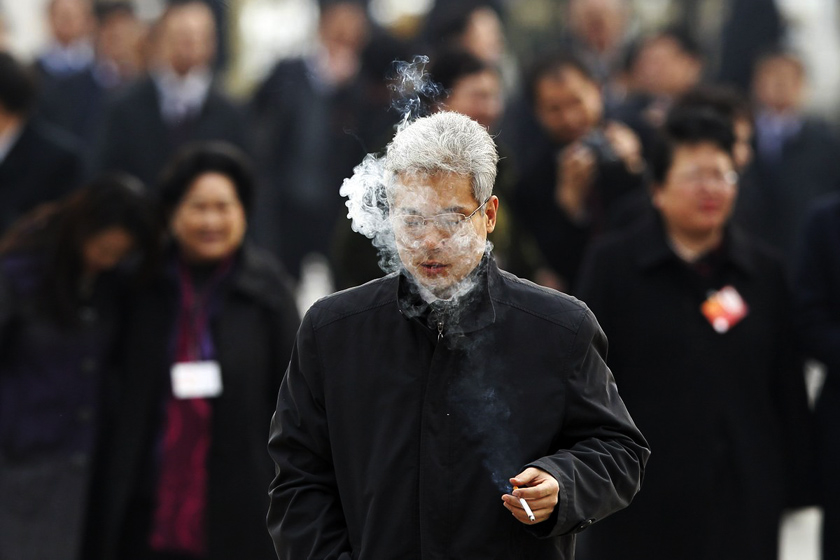 3月4日，北京，一名吸烟的委员走过天安门广场。_两会：表情