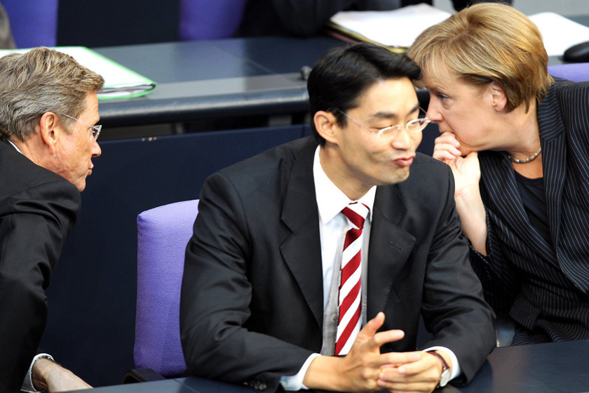 2011年9月6日，德国柏林，德国总理默克尔与德国外长韦斯特韦勒（左）交谈，坐在他们中间的德国经济部长勒斯勒尔撅起嘴巴，样子十分可爱。 Wolfgang Kumm/东方IC _世界政坛亲密“敌人”