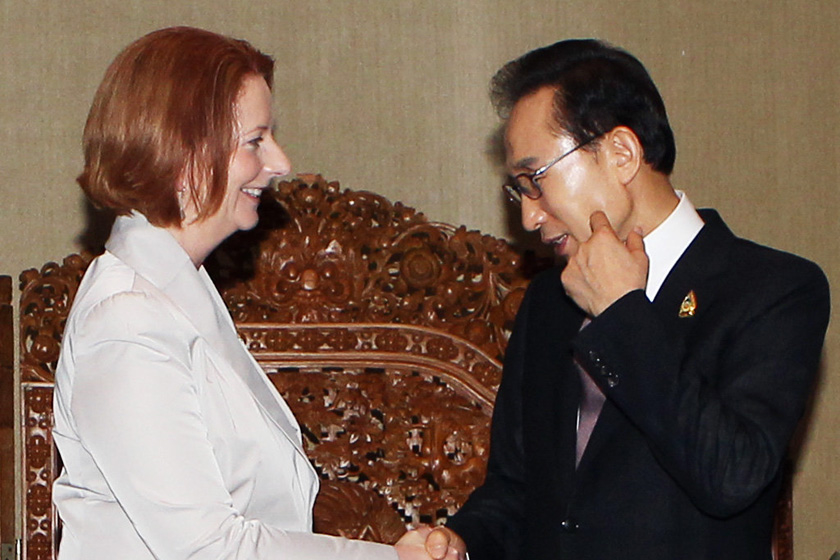 2011年11月19日，印度尼西亚巴厘岛，韩国总统李明博在与澳大利亚总理吉拉德握手时指着自己的脸颊，于是吉拉德又吻了他一次。 CFP_世界政坛亲密“敌人”