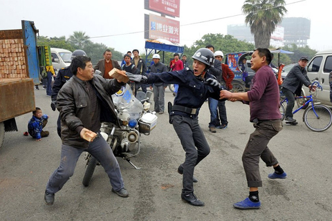 2012年3月17日，浙江瑞安，两名街头摆摊卖砖的中年男子因琐事吵架，结果矛盾升级，互缠着扭打在一起。派出所民警赶到现场后极力劝架，但两位中年男子“越战越勇”互扔砖头。最后，在民警极力制止下，此番街头争斗才告一段落。 孙凛/东方IC