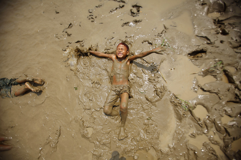 2012年3月20日，缅甸勃固河岸，一个孩子在泥浆中玩耍。 REUTERS/Staff_财新每周图片(2012.3.17-3.23) 