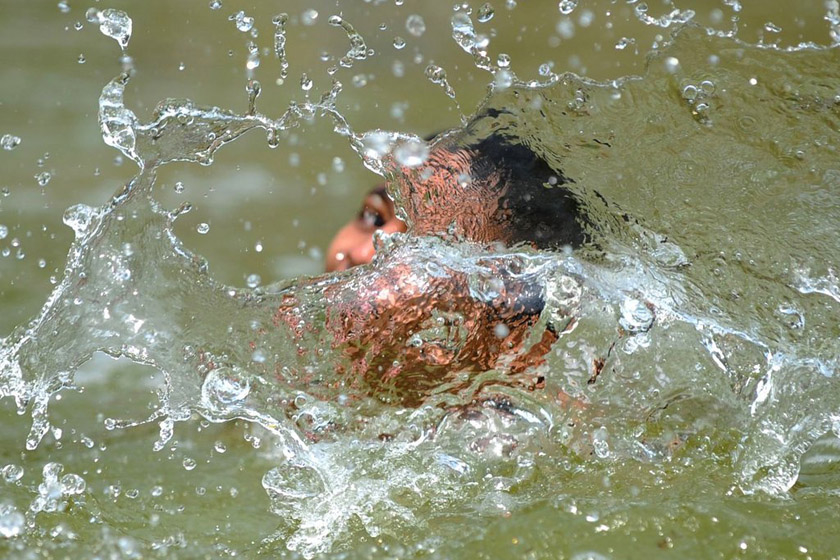 2012年3月18日，印度新德里，一个孩子在印度门附近的池塘里解暑。 AJJAD HUSSAIN/东方IC_财新每周图片(2012.3.17-3.23) 