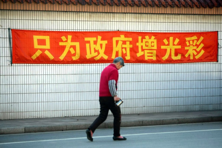 4月3日，江阴长江村，村民从张贴着“只为政府添光彩”的条幅旁走过。 翁磊/东方IC _武汉“城中村”村民每人领百克黄金