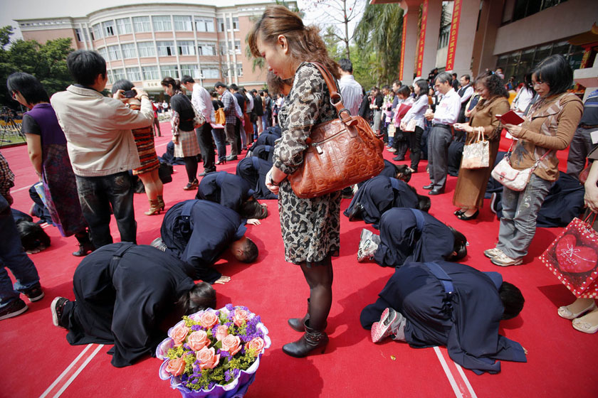 參加成人禮的學生身著長袍及發冠祭拜中華民族始祖,並對家長行跪拜禮