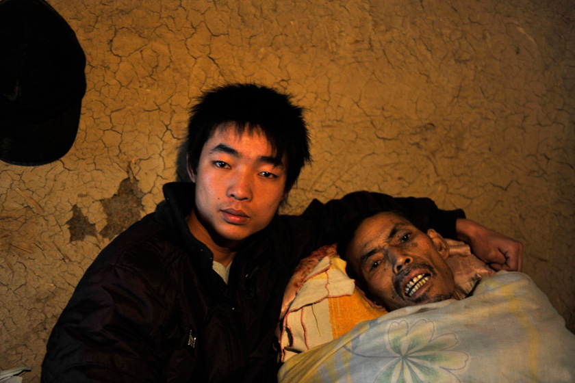 3月22日，陕西镇安，程即来和父亲合影留念。早年丧妻的程仪兴靠着那双干农活的手把三个孩子拉扯大。眼看着两个女儿嫁人了，儿子也考上了大学，不料，他却因积劳成疾，累垮了。就在程仪兴的生命被医生判了“死刑”的时候，正在读大二的儿子程即来选择了陪伴父亲走完最后的日子。  华商报胡国庆/CFP_财新每周图片(2012.4.14-4.20) 