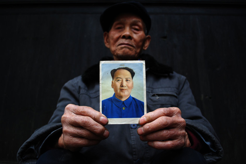 4月14日，贵州省岑巩县，91岁高龄的刘荣光老人展示自己在抗美援朝时得到的一张毛泽东像。  胡雁/CFP_财新每周图片(2012.4.14-4.20) 