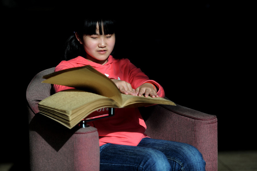 2012年4月23日，南京图书馆视障人书刊借阅室，一名盲人学生在“阅读”盲文书箱。 柳一凡/CFP_财新每周图片(2012.4.21-4.27) 