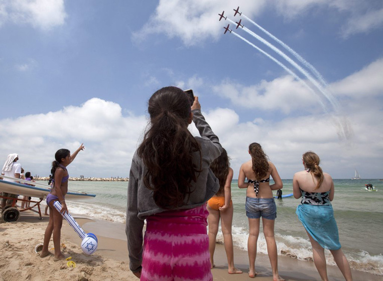 2012年4月26日，以色列特拉维夫，海滩边的民众观看空军飞行表演。 CFP_财新每周图片(2012.4.21-4.27) 