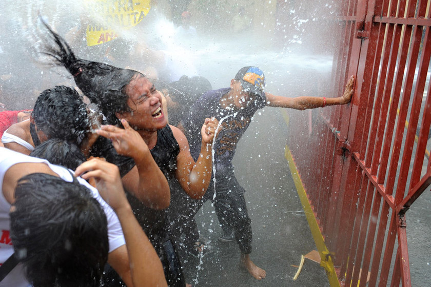 2012年4月25日，菲律宾马尼拉，警方用水枪向在马拉坎南宫附近示威的学生喷射。 NOEL CELIS/东方IC_财新每周图片(2012.4.21-4.27) 