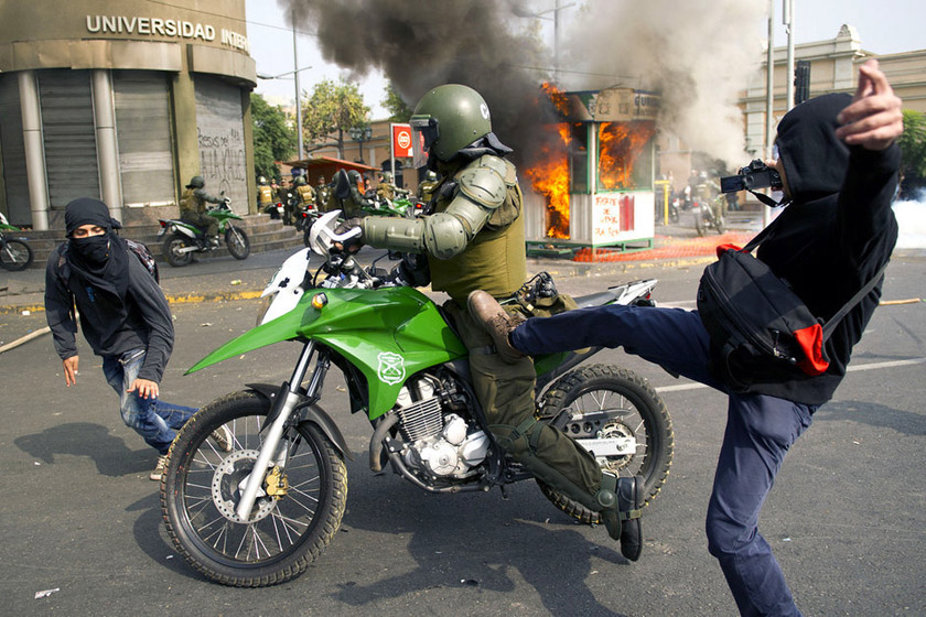 2012年4月25日，智利圣地亚哥，抗议者和警察发生冲突。智利学生集会抗议，要求政府实施免费的公共教育。 MARTIN BERNETTI/东方IC_财新每周图片(2012.4.21-4.27) 