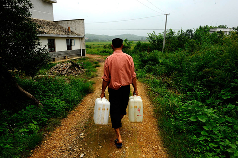 2009年8月6日，湖南浏阳，严重的镉污染致使双桥村的水无法饮用，村民李良南每天从几公里外取水，再挨家挨户送到村民家，暂解水荒。方谦华/CFP