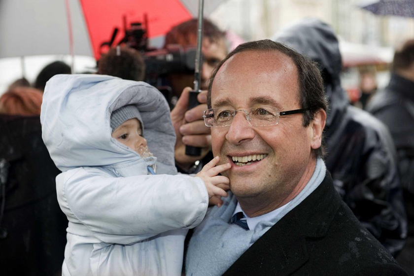 2012年4月21日，奥朗德在大选第一轮投票前日抓紧造势，被小孩摸脸。 CFP_法国新任总统奥朗德