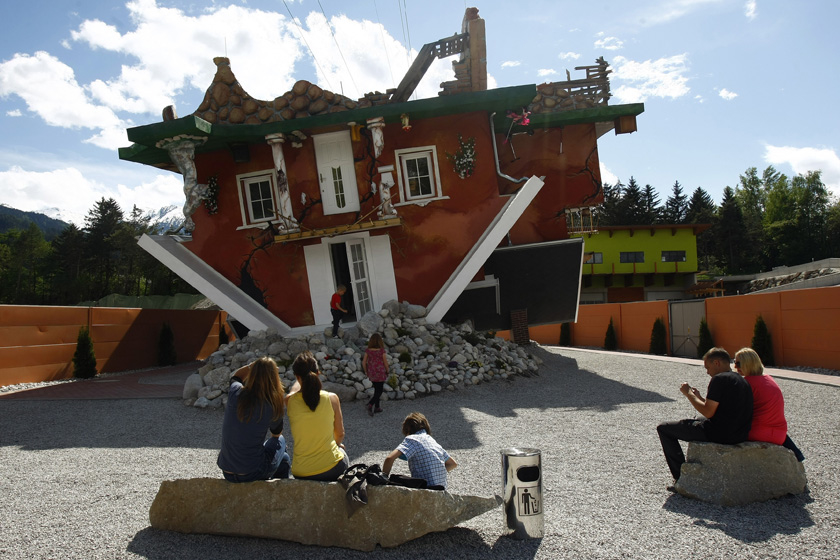2012年5月5日，奥地利蒂罗尔州，人们观看建筑师的创意作品“颠倒房屋”。这栋房子的内部设施及停车位都是倒立的，旨在吸引游客。 REUTERS/Dominic Ebenbichler_财新每周图片(2012.5.5-5.11) 
