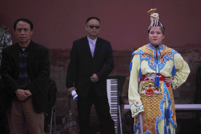 2010年10月16日，北京劳动人民文化宫，一位外国女孩装扮成“贵妃”的扮相，站在红墙边休息。 新京报赵亢/CFP_特辑：老外在北京