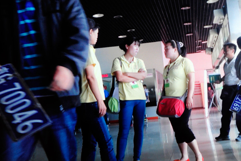 5月15日，北京旧机动车交易市场过户大厅，身穿黄色T恤的代理们聚集在大厅入口拦生意，大厅里有许多这样的代理。 新京报尹亚飞/CFP_拼装奥迪头身尾型号各不同