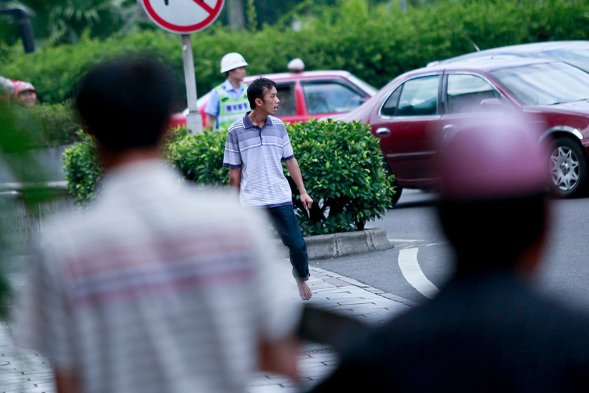 5月24日上午，广东佛山，疑似吸毒的持刀者在街头游走。  郭继江/CFP_佛山警方用钢叉制伏“双刀男”