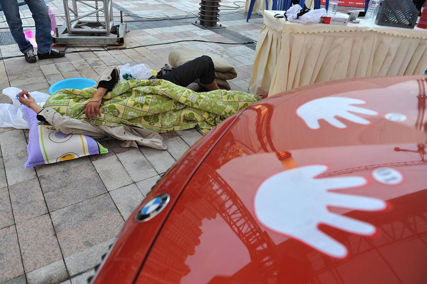 5月30日，四川省成都市， 休息15分钟，参赛选手何佳抓紧睡觉，被子席子都是家人送来。   成都商报/CFP_为争抢5年使用权 选手摸宝马车80余小时