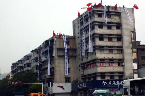 6月6日，湖北宜昌西陵一路的居民将写满抗议标语的条幅挂在被开发商强行破坏的楼房上。 刘蛟/东方IC