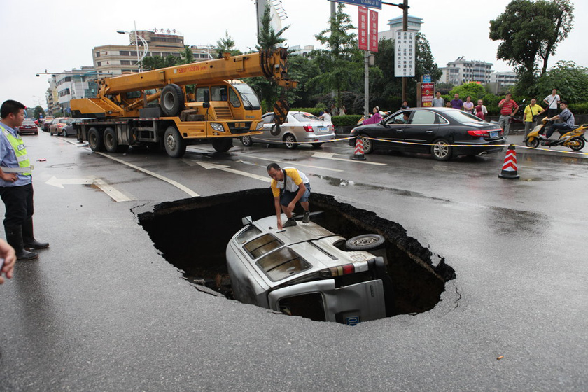 6月7日，一辆微型面包车跌入塌陷的坑中。  何志勤/CFP_桂林路面突然塌陷致小车跌落