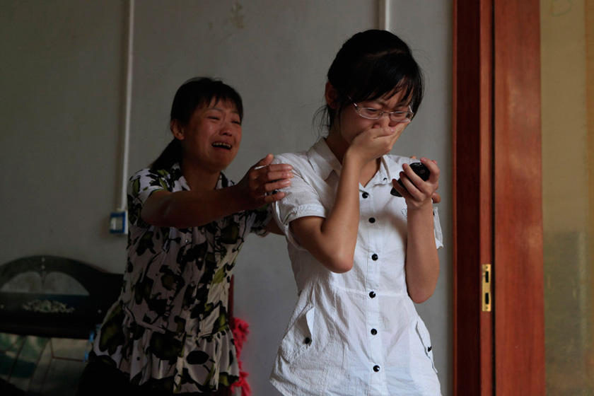6月8日，西安市阎良区关山镇刘家村，刘庆从手机上看到了爸爸去世的报道，泪水一下子涌了出来，妈妈在一旁安慰孩子。 华商报董国梁/CFP_考生高考结束才知父亲已去世两月