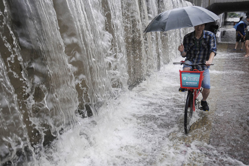 6月18日，杭州，大量的雨水流下路面，形成了“小瀑布”。 CFP_大雨侵袭杭城 市民街头捉鱼