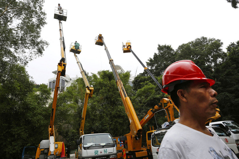 6月25日，香港候任特首梁振英山顶豪宅余下僭建开始清拆，工人先清拆车位僭建上盖，大批记者在现场拍摄。  Vincent Yu/东方IC