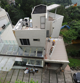 2012年6月25日，香港候任特首梁振英山顶豪宅余下僭建开始清拆。大批记者在现场拍摄，甚至有媒体租用6台吊臂车拍摄清拆情况。香港屋宇署人员上周接到媒体举报，到梁宅调查，发现梁宅存在两个僭建玻璃棚，还有另外4处违规僭建。梁宅一如唐英年府邸，在地面车位下僭建一个面积240方尺的地库。