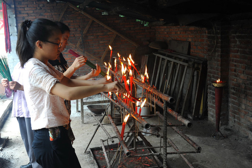 7月3日，民众在寺中上香。  东方IC_四川绵阳红恩寺供奉毛泽东等伟人金身