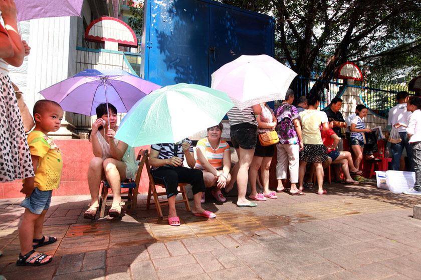 7月11日上午，广西柳州，距报名还2天时间，家长已经开始在烈日下排队。 颜篁/CFP_柳州一幼儿园招生引发“排队大战”