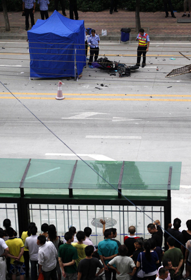 7月17日，广东佛山，车祸现场被封锁，大批警察到场进行勘察。其中一名死者尸体被简易帐篷遮盖着。 东方IC_佛山疑似黑帮街头火并 3车相撞2死1伤