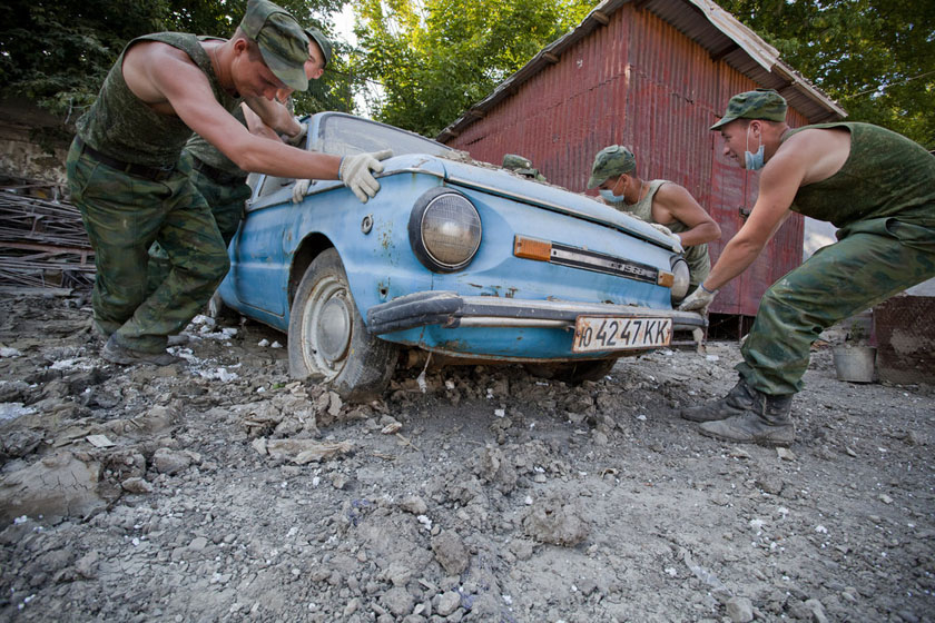 2012年7月18日，俄罗斯克雷姆斯克，几个士兵试图搬动一辆在洪水中损坏的汽车。 CFP_财新每周图片(2012.7.14-7.20)