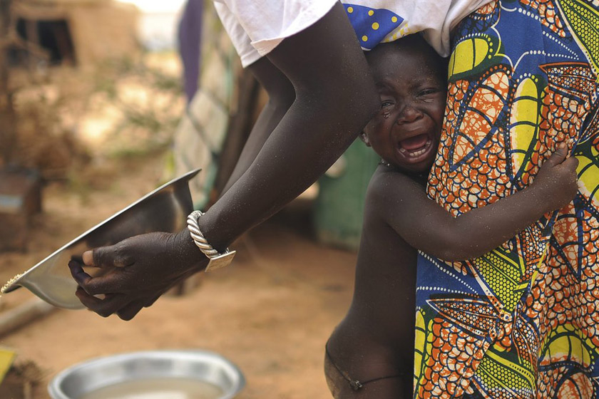 2012年7月4日，布基纳法索多利，当地一处难民营内一个小男孩抱着妈妈哭泣。 CFP_财新每周图片(2012.7.14-7.20)