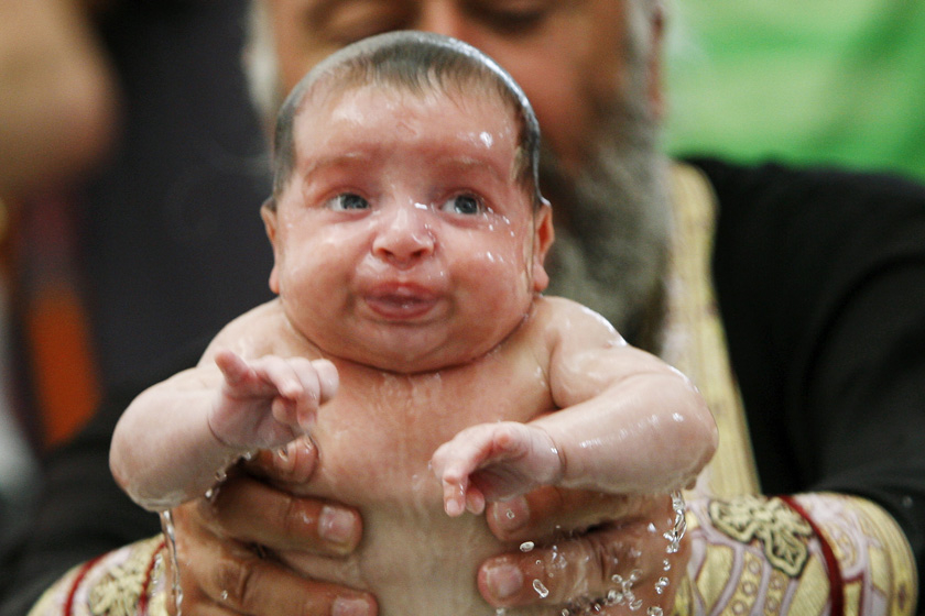 2012年7月13日，格鲁吉亚首都第比利斯，一名婴儿在一场弥撒中受洗。自2008年以来，在该国主要的大教堂圣三一大教堂内，已有超过1.2万名儿童在23场大型弥撒上接受了格鲁吉亚东正教会的洗礼。 REUTERS/David Mdzinarishvili_财新每周图片(2012.7.14-7.20)