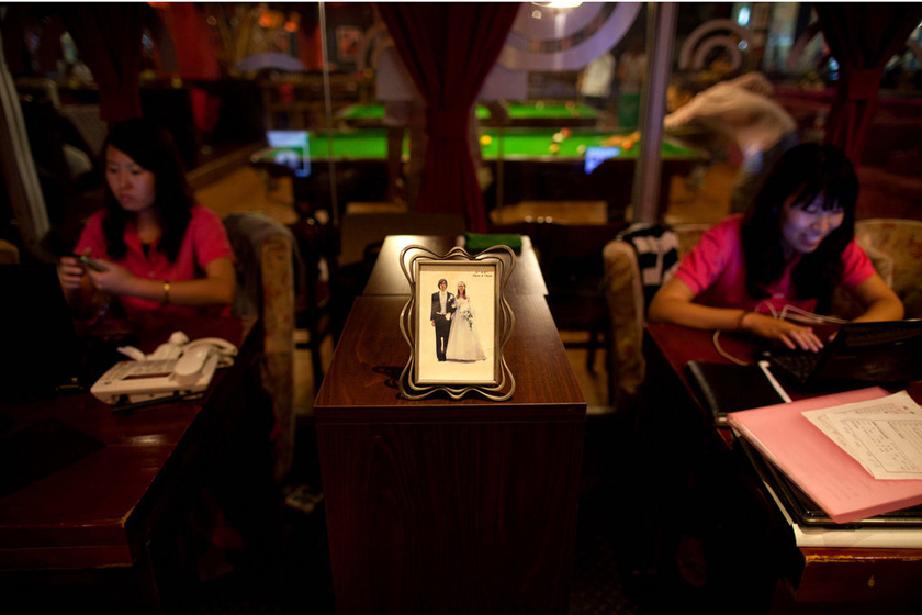 2012年6月28日，北京，一张结婚照摆在单身俱乐部员工面前。 Ed Jones/东方IC_财新每周图片(2012.7.14-7.20)