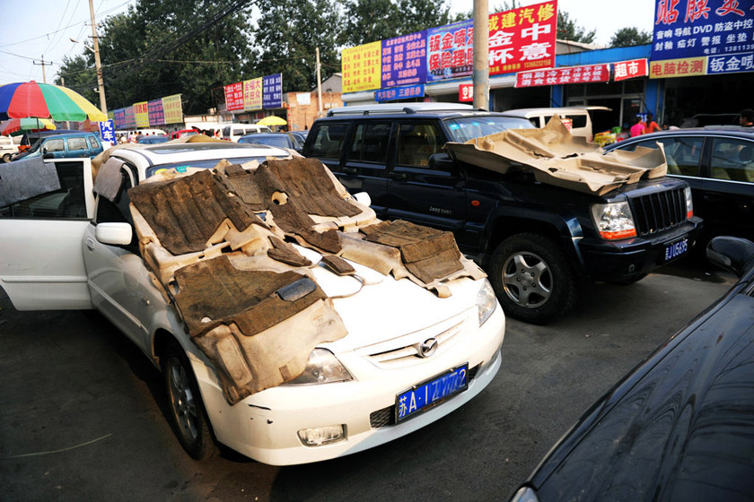 7月24日，北京，十八里店汽配城，一家汽修店门口停着被暴雨浸泡的汽车。 陆岩/东方IC_暴雨过后北京汽修厂爆满