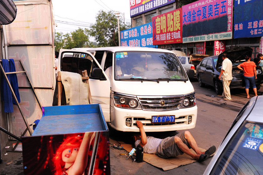 7月24日，北京，十八里店汽配城，一家汽修店工作人员正在对被淹汽车进行调试。 陆岩/东方IC_暴雨过后北京汽修厂爆满