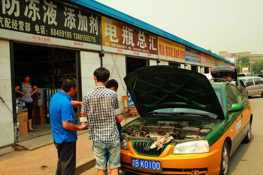 7月24日，北京，西郊汽配城，工作人员正在对被淹出租汽车进行调试。 旮旯/东方IC_暴雨过后北京汽修厂爆满