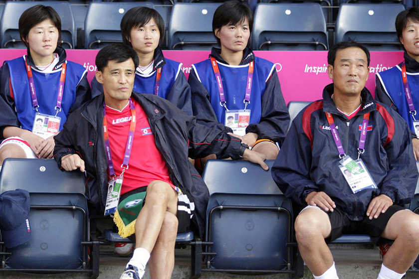 7月25日，汉普敦公园球场，比赛中断期间朝鲜女足教练申以勤（左二）在场边等候。 GRAHAM STUART/东方IC_朝鲜女足因错配韩国国旗一度罢赛